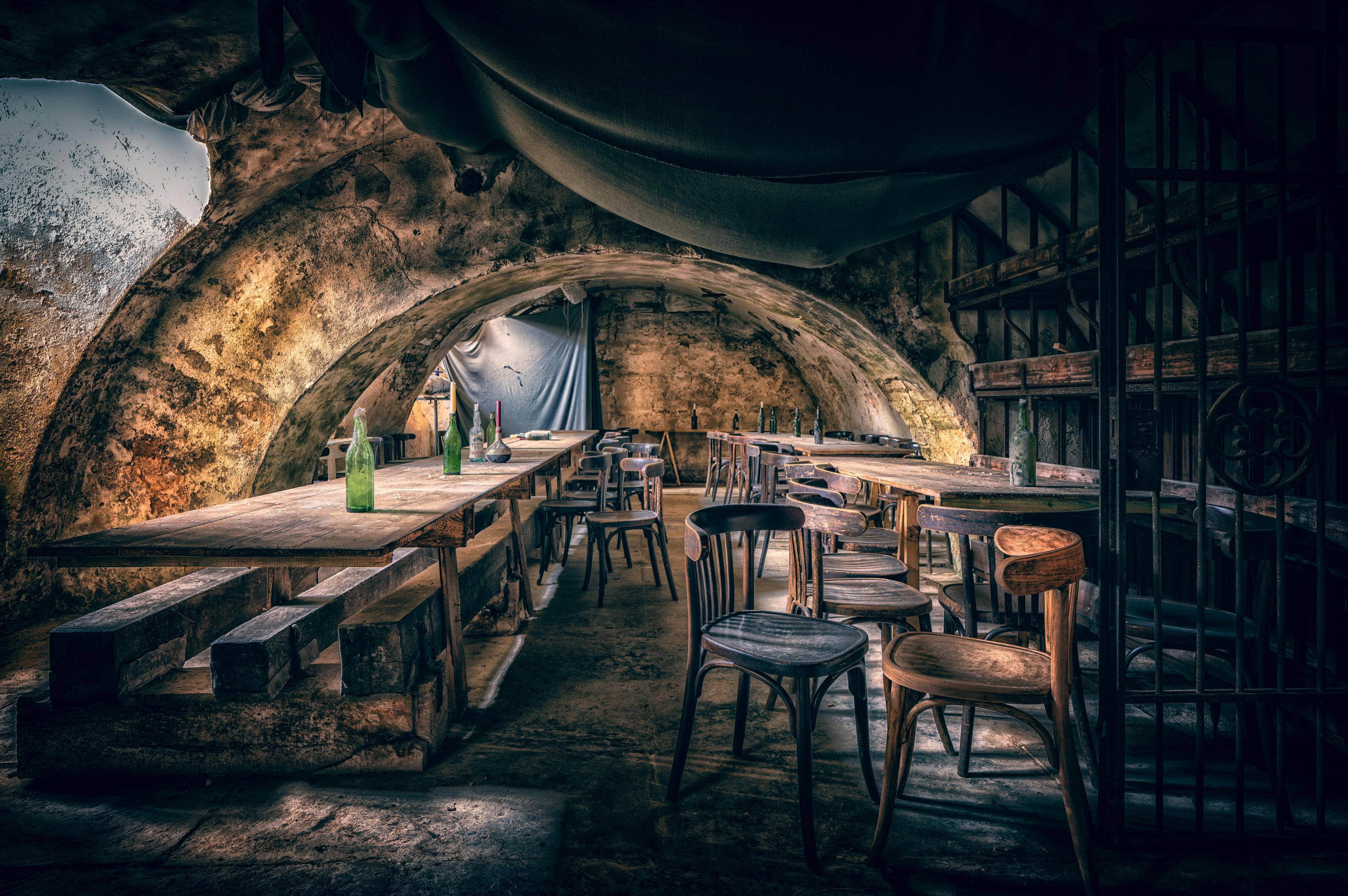 A candlelit fantasy tavern table with wooden boards and cider — atmosphere for a murder mystery dinner
